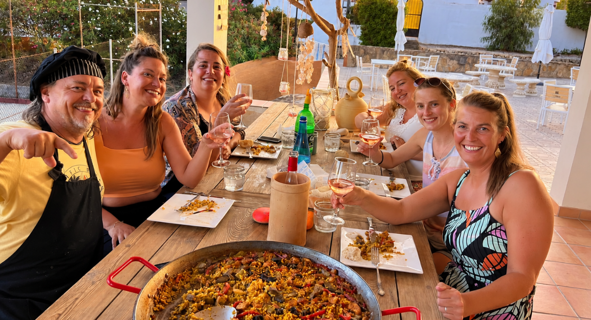 Grupo de amigas compartiendo paella y vino en la terraza de Pool Bar